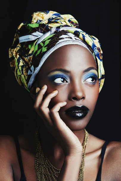 Ze is een echte Afrikaanse schoonheid. Een mooie Afrikaanse vrouw poseren tegen een zwarte achtergrond. - Foto, afbeelding