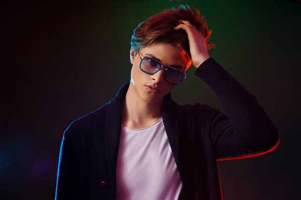 Neon light portrait of handsome male model with dark medium length hair, hairstyle, wear sunglasses - 写真・画像