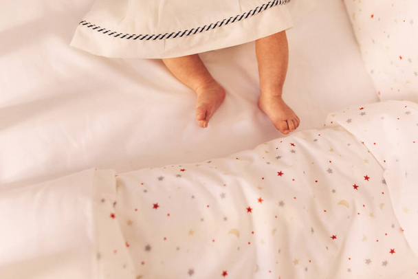 little girl lying on bed with pink blanket - Φωτογραφία, εικόνα