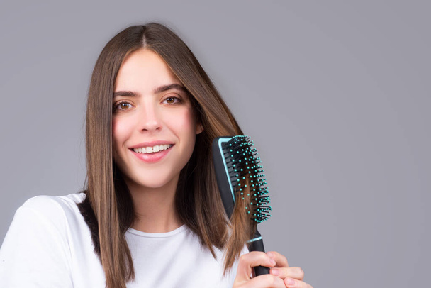 Close up portrait of happy beautiful girl with shiny hair with comb. - Foto, afbeelding