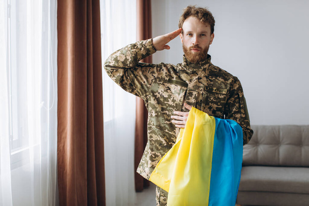 Egy sárga-kék zászlós, katonai egyenruhás ukrán katona portréja - Fotó, kép