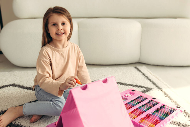 Portret małej uroczej dziewczynki. dziewczyna maluje w domu na podłodze - Zdjęcie, obraz