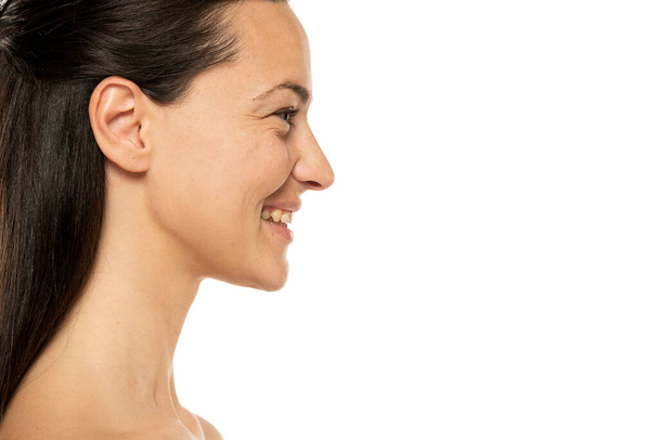Profil, boční pohled portrét krásné usmívající se ženy bez make-upu na bílém pozadí. - Fotografie, Obrázek