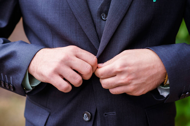 correct button on jacket, hands close-up, dressing, man's style, stylish man. - Фото, изображение