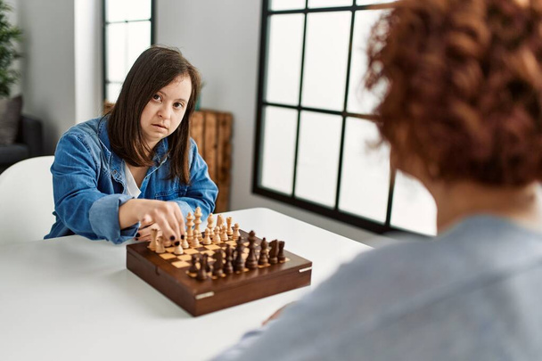 Mère mature et fille du syndrome du duvet jouant au jeu d'échecs à la maison - Photo, image