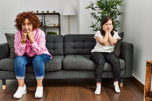 Maturo madre e figlia sindrome di Down guardando sconvolto e arrabbiato dopo la discussione a casa - Foto, immagini