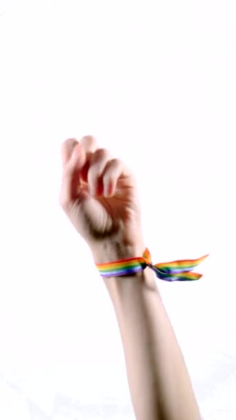 El, dört parmağı gösteren LGBT bayrağı renginde bir bilezik takıyor. Dikey video. - Video, Çekim
