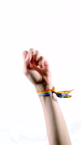 A felemelt kar karkötőt visel az LMBT zászló színeivel. LMBT szimbólum. Függőleges videó. - Felvétel, videó