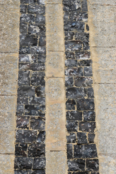 Colonnes ornementales en silex tricoté dans le mur de l'église - Photo, image