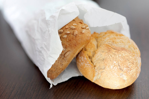 friss ropogós kenyértekercsek papírzacskóban - Fotó, kép