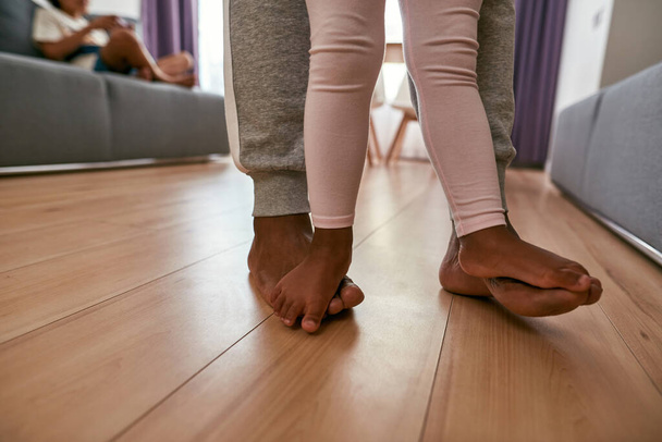 Barefoot legs of father and daughter go on floor - Фото, изображение