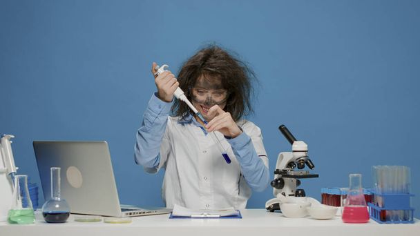 Wahnsinniger goofy Wissenschaftler mit Mikropipette und Reagenzglas - Foto, Bild