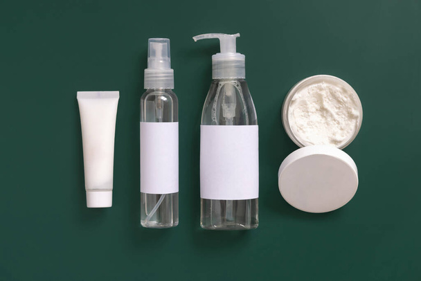 Selbstgemachte Kosmetik in Plastiktuben und Flaschen auf dunkelgrüner Draufsicht. Markenverpackungsattrappe. Biologische Naturkosmetik für die Haut- und Haarpflege - Foto, Bild