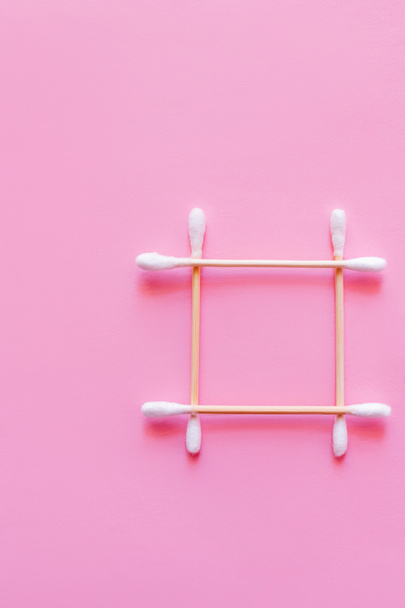 top view of square made of cotton swabs on pink background - Фото, изображение