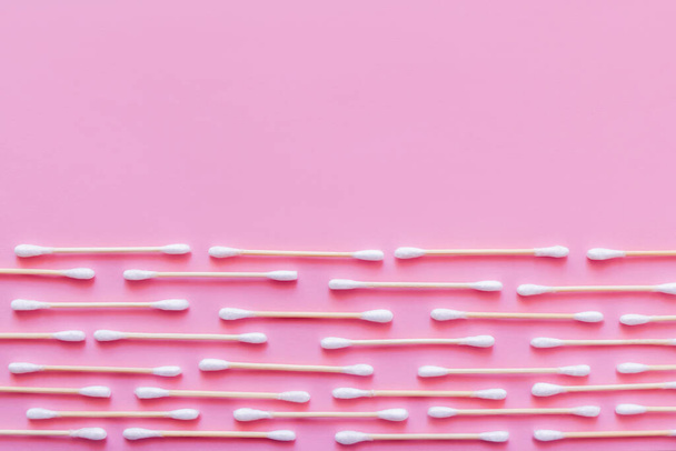 horizontal rows of cotton swabs on pink background, top view - Φωτογραφία, εικόνα