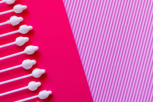top view of cosmetic cotton swabs on bright pink and violet background - Fotografie, Obrázek