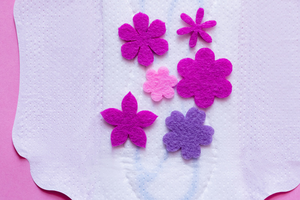 top view of purple flowers on white breathable panty liner on violet background - Photo, Image