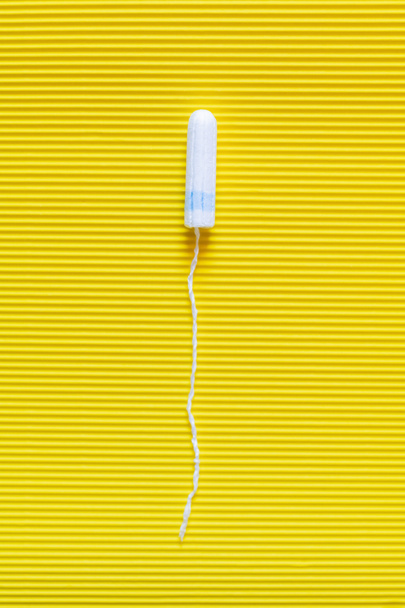 top view of hygienic tampon on bright yellow textured background - Foto, Imagen