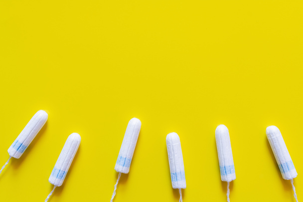 top view of white cotton tampons on yellow background with copy space - Фото, изображение