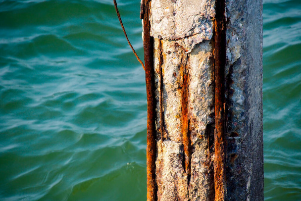 Kolumny, które były narażone na działanie wody morskiej, erozji i rdzy stali. - Zdjęcie, obraz