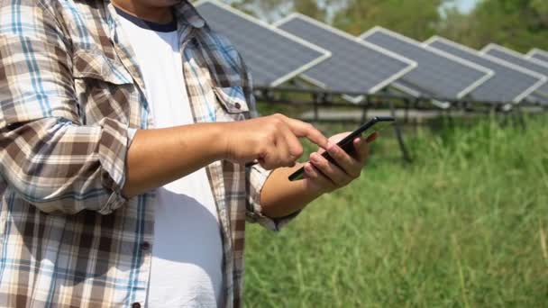 Los agricultores asiáticos utilizan tabletas para ajustar el grado de las células solares y comprobar el rendimiento de las células solares después de la lluvia y manchas de polvo y suciedad en la célula solar. Concepto de tecnología agrícola. - Metraje, vídeo