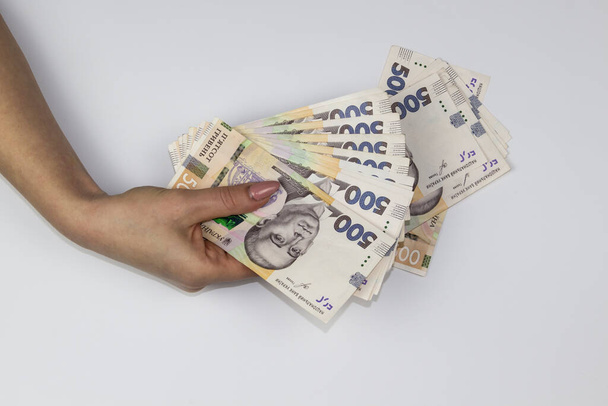 Vrouwelijke handen houden Oekraïense geld vast. Enkele duizenden Hryvnia bankbiljetten door 500. Geld van Oekraïne. - Foto, afbeelding