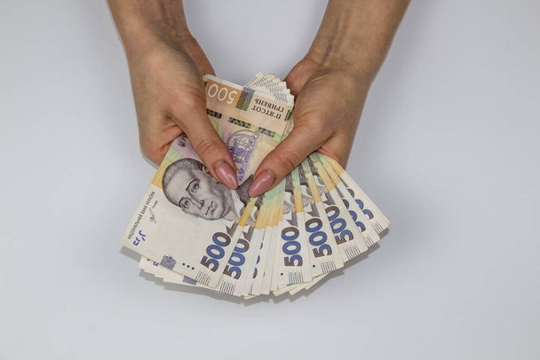 Женщины держат украинскую валюту. Шесть тысяч пятьсот гривен банкнот по 500. Деньги Украины. - Фото, изображение