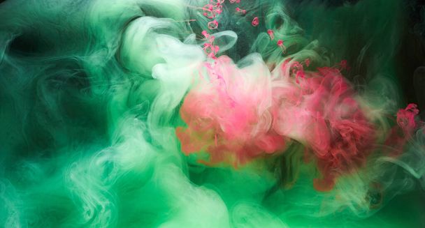 Green pink smoke on black ink background, colorful fog, abstract swirling touch ocean sea, acrylic paint pigment underwater - Photo, Image