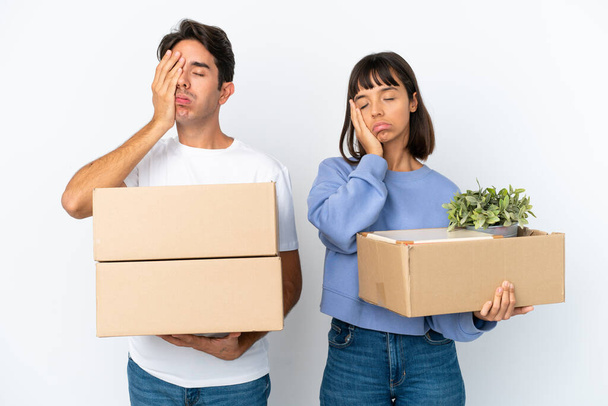 Young couple making a move while picking up a box full of things isolated on white background with surprise and shocked facial expression - Photo, Image