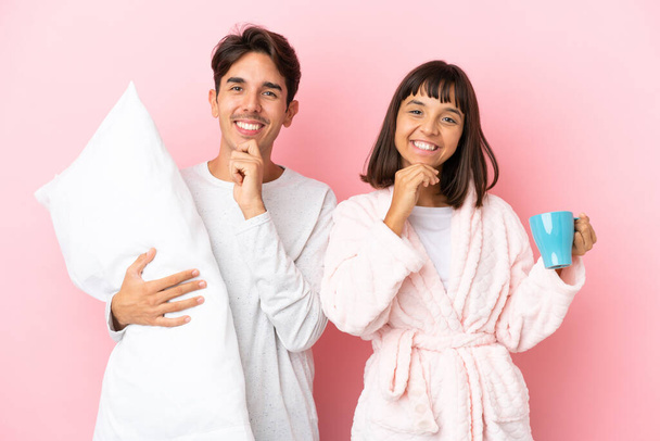 Young couple in pajamas isolated on pink background smiling with a sweet expression - Fotoğraf, Görsel