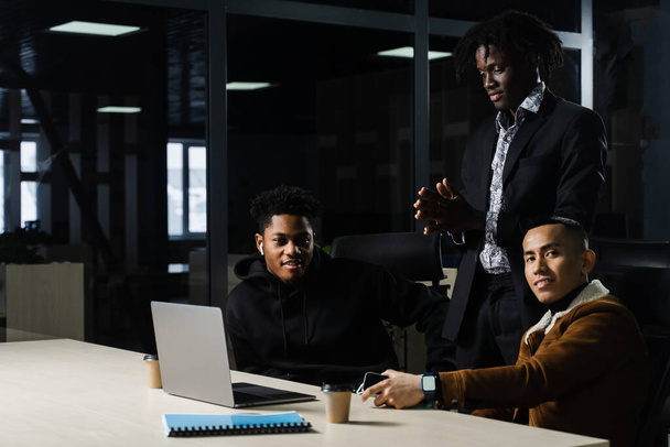 Grupo multinacional de colegas que trabajan en línea en el proyecto en la sala de reuniones. negro africano negocios hombre y asiático trabajo en equipo juntos - Foto, imagen