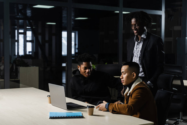 Grupo multinacional de colegas que trabajan en línea en el proyecto en la sala de reuniones. negro africano negocios hombre y asiático trabajo en equipo juntos - Foto, imagen