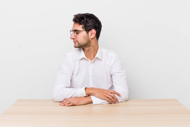 hispanic handsome man on profile view thinking, imagining or daydreaming. businessman and desk concept - Fotoğraf, Görsel