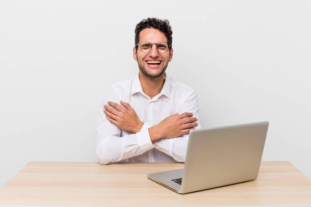 hispanic handsome man laughing out loud at some hilarious joke. businessman and desk concept - Foto, immagini