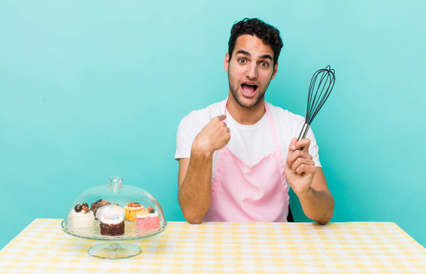 hispanic handsome man feeling happy and pointing to self with an excited. home made cakes cocnept - Fotoğraf, Görsel