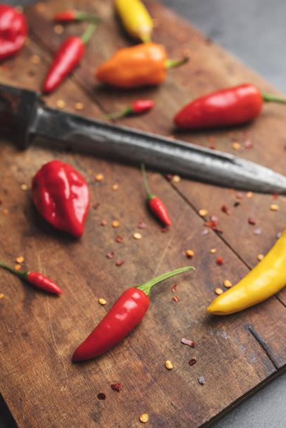 Variety of fresh and dried chili peppers on rustic background - Photo, Image