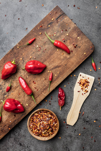 Różnorodność świeżej i suszonej papryki chili na rustykalnym tle - Zdjęcie, obraz