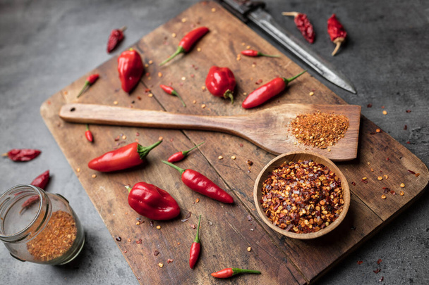 Variety of fresh and dried chili peppers on rustic background - Photo, image