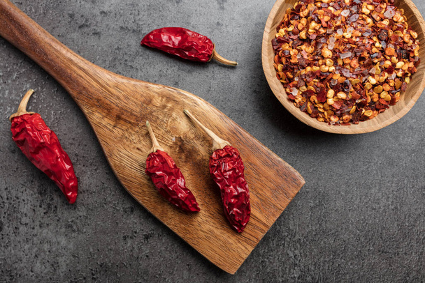 Variety of fresh and dried chili peppers on rustic background - Fotó, kép