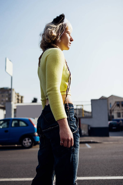 Молодая нонконформистка-бунтовщица, гендерная жидкость, позирующая на открытом воздухе, глядя на многообещающие и задумчивые - Фото, изображение