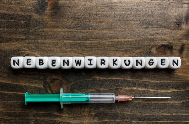 Corona virus Covid-19 vaccine text in German on wooden background  - Φωτογραφία, εικόνα