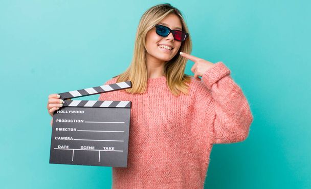 pretty blonde woman smiling confidently pointing to own broad smile. cinema concept - Photo, image