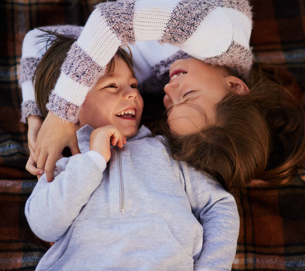 Youre my brother and my best friend. High angle shot of a cute little girl hugging her brother while they lie on a blanket together. - Foto, imagen