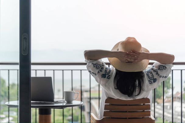 Work-Life balance, life quality, work from home and travel concept with business woman relaxing, take it easy, resting in  hotel resort, condominium, or apartment luxury living room with notebook - Photo, Image