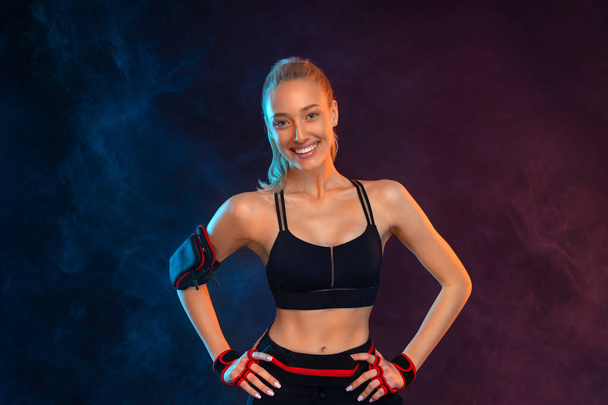 Strong athletic fit woman on black background wearing in the sportswear. Fitness and sport motivation idea for social media post. - Foto, Bild