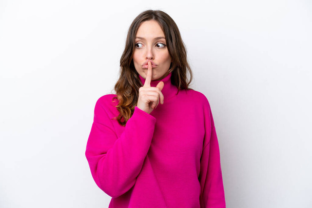 Young caucasian woman isolated on white background showing a sign of silence gesture putting finger in mouth - Foto, immagini
