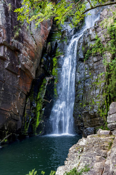 Belle cascade de Veu da Noiva entre les pierres couvertes de mousse et la végétation située dans une zone de nature entièrement préservée dans l'état du Minas Gerais, Brésil - Photo, image