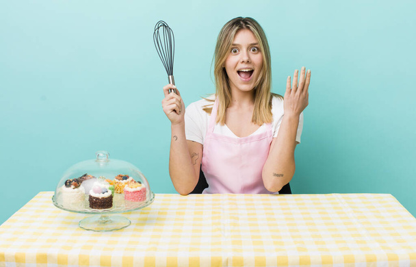 pretty blonde woman feeling happy and astonished at something unbelievable. homemade cake concept - 写真・画像