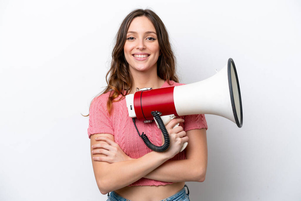 Young caucasian woman isolated on white background holding a megaphone and smiling - Foto, Imagem