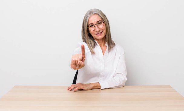 senior  gray hair woman smiling and looking friendly, showing number one. desk and business concept - Valokuva, kuva